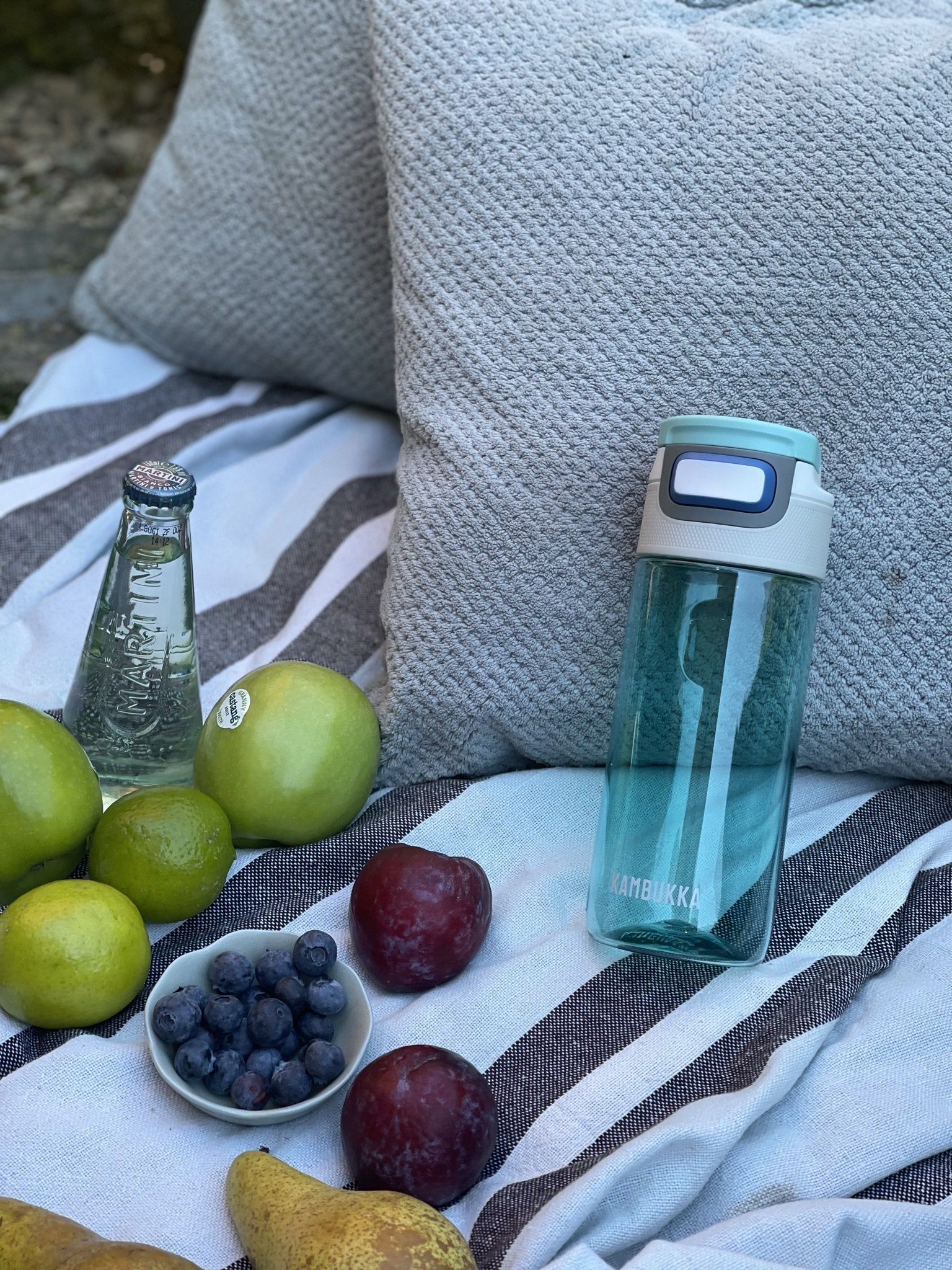 Kambukka Elton 500 ml Ice Green Water bottle standing against a grey pillow