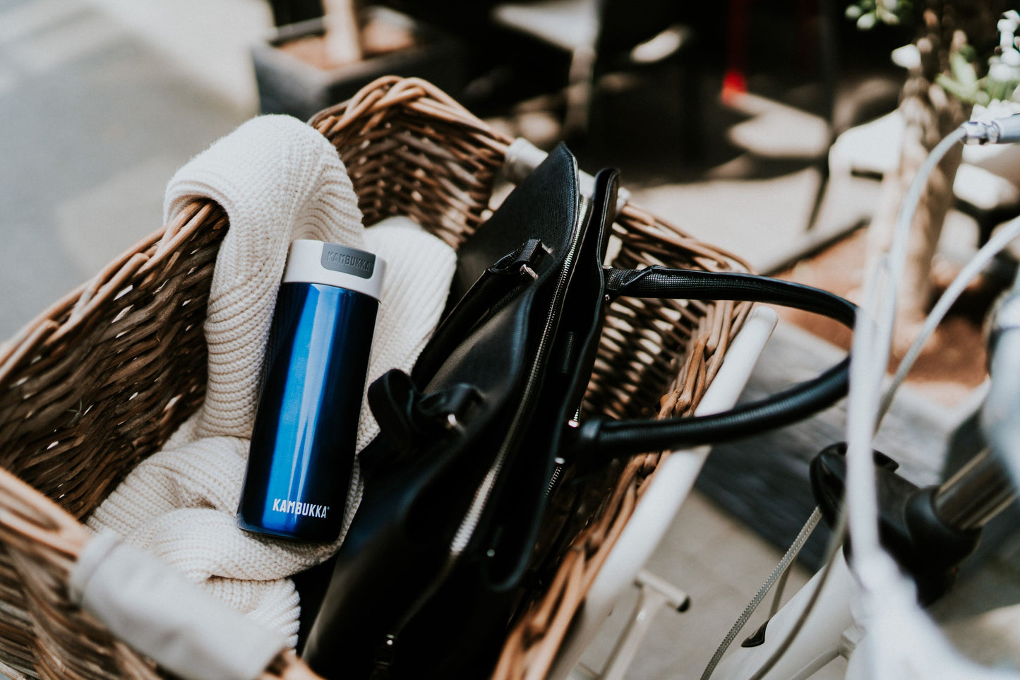 Kambukka Olympus Blue travel mug laying in a bag's bike